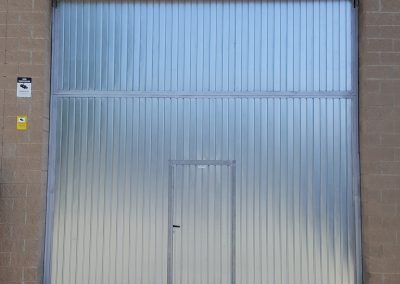 Porta nau industrial amb accés peatonal